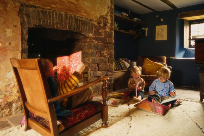 The children reading a book in the snug