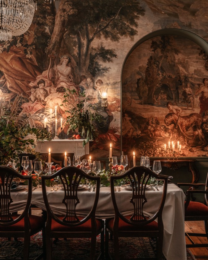 Orpheus: a moody, dramatic dining room setting with candles and mural wallpaper