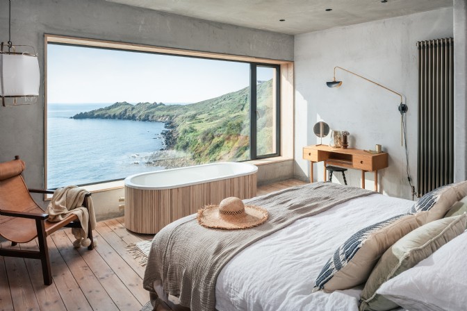 A bed facing a huge picture window that overlooks the ocean at Ukiyo in Coverack, Cornwall