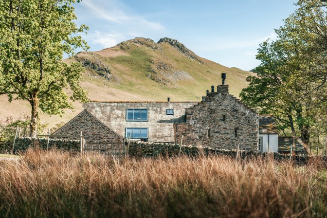 Gaia Farmhouse nestled in the green landscape in the Lake District