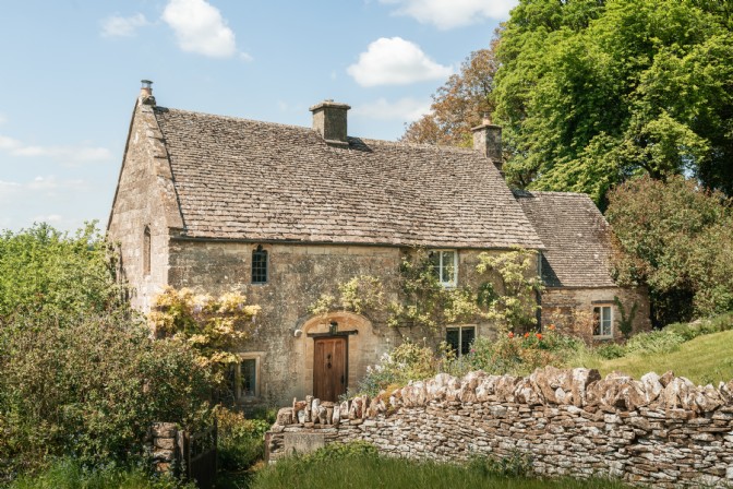 Under the Yew Tree: a monastery cottage surrounded by a low wall and lush garden