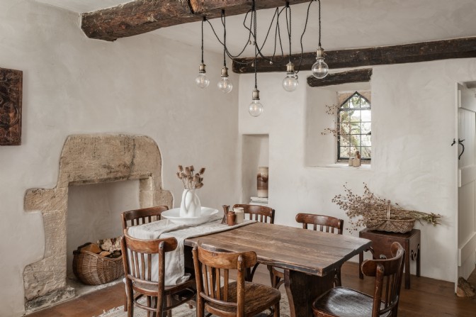 An ancient, modernised cottage dining room with a wooden table at Under the Yew Tree