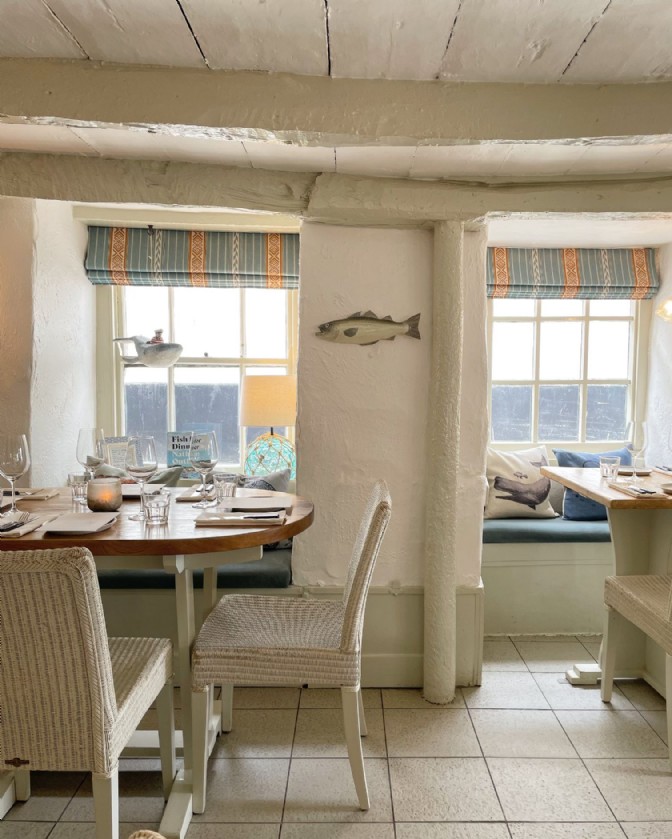 A small table in front of a window at Outlaw's Fish Restaurant in Port Isaac in Cornwall