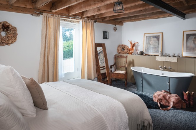 The ground floor master bedroom is complete with a standalone bath tub