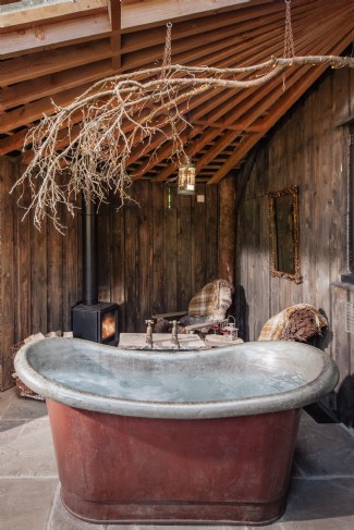 Relax in a deep copper bathtub next to a crackling woodburner