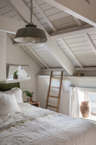 Quirky windows and wooden beams make the king-size bedroom a luxurious space