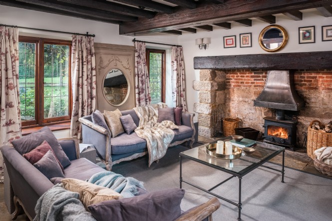 In the living room of Roserai, sofas face the wide inglenook fireplace