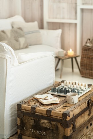 The living area is a cosy space with its large fire and layered linens